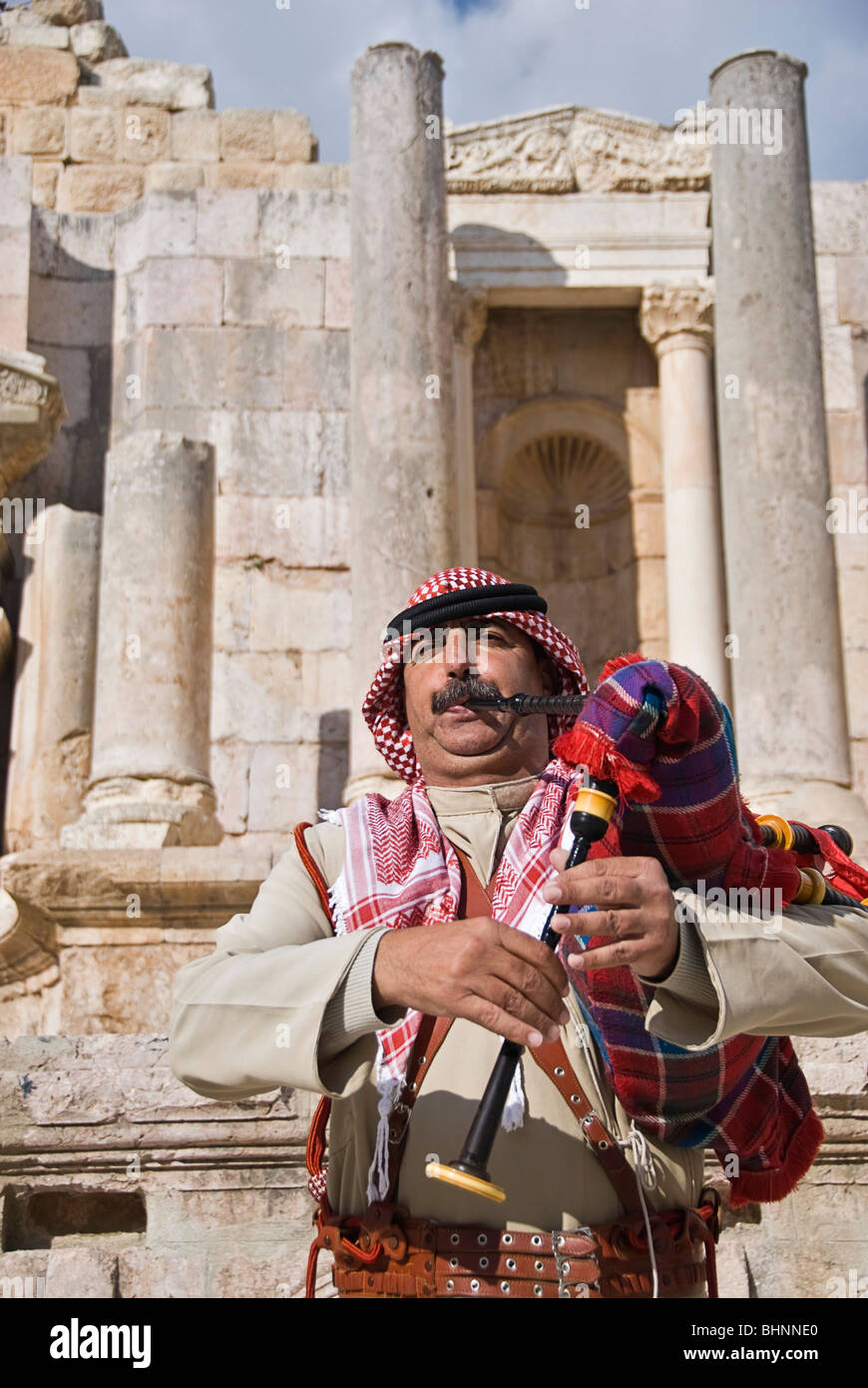 Man blowing le pipa à les vestiges romains de Jerash, Jordanie, Asie. Banque D'Images