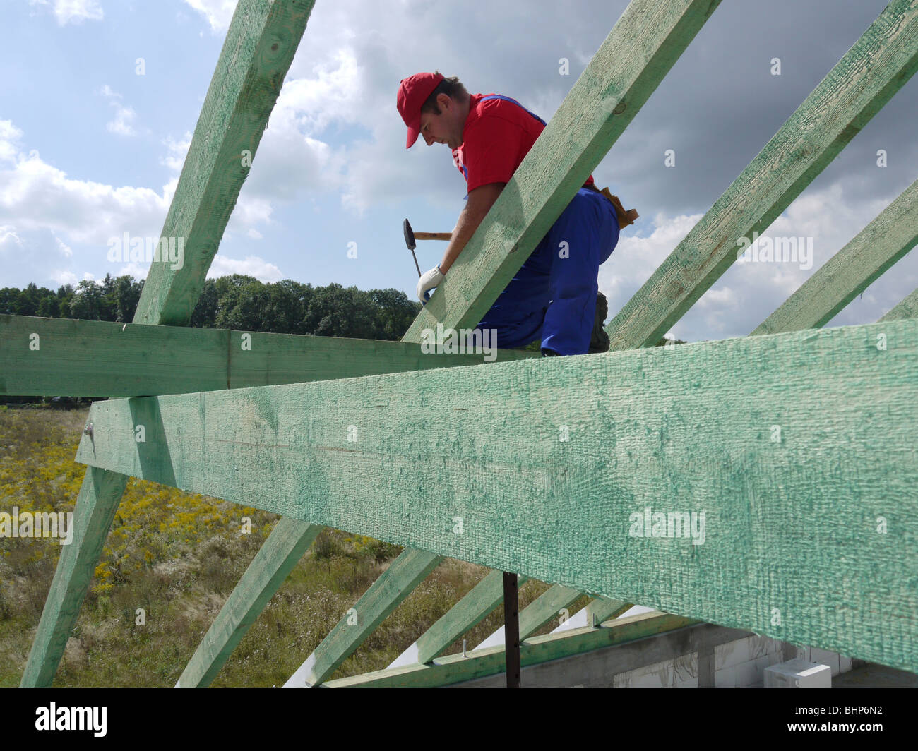 Carpenter la conduite d'un clou dans chambre rafter poutre ossature Banque D'Images