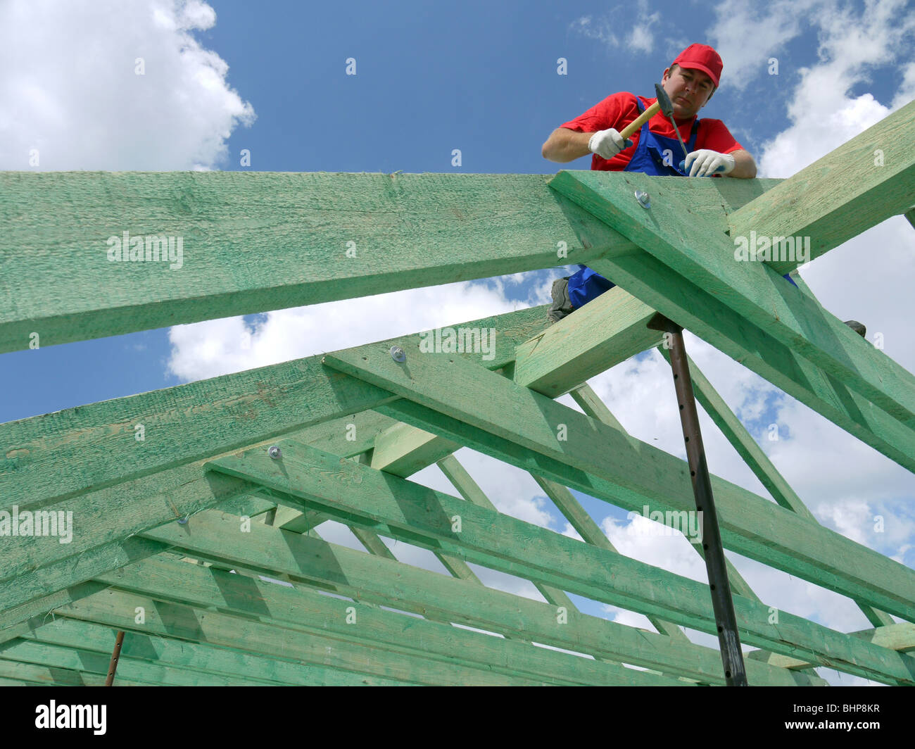 Carpenter la conduite d'un clou dans chambre rafter poutre ossature Banque D'Images