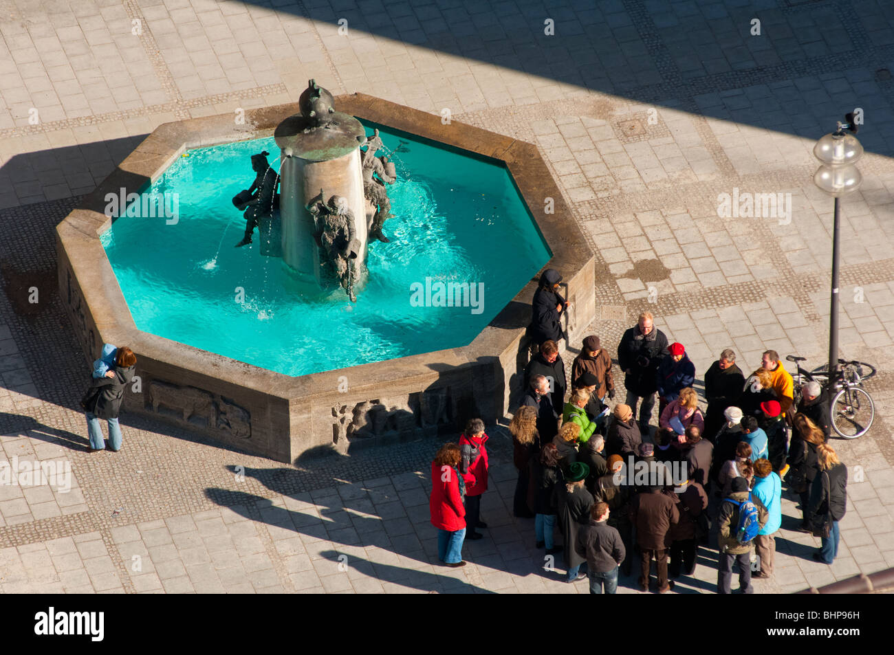 Tour group rassembler près d'une fontaine dans la place Marienplatz, Munich, Allemagne Banque D'Images