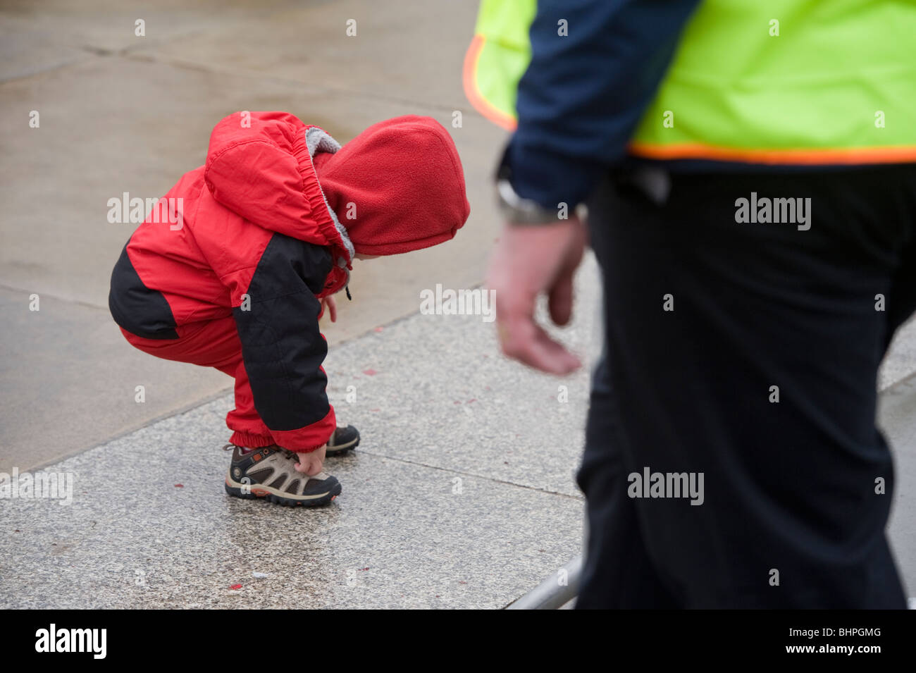 Un jeune enfant chinois attacher ses lacets pendant les célébrations du Nouvel An chinois à Trafalgar Square London UK Banque D'Images