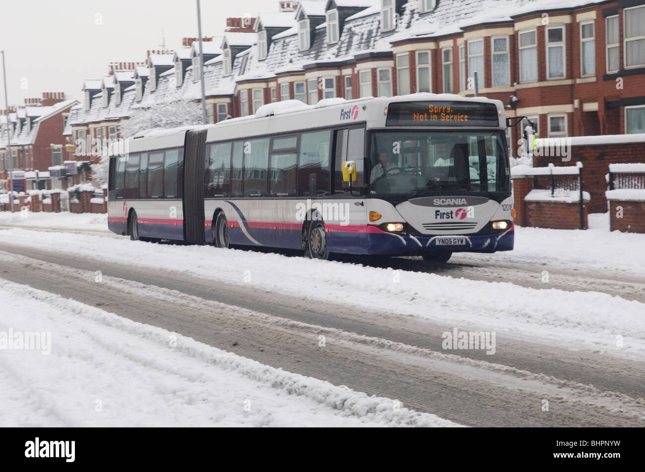 Poing 135 conduite d'autobus avec prudence dans un mauvais temps sur une route glissante couverte de glace et de neige à Manchester, UK Banque D'Images