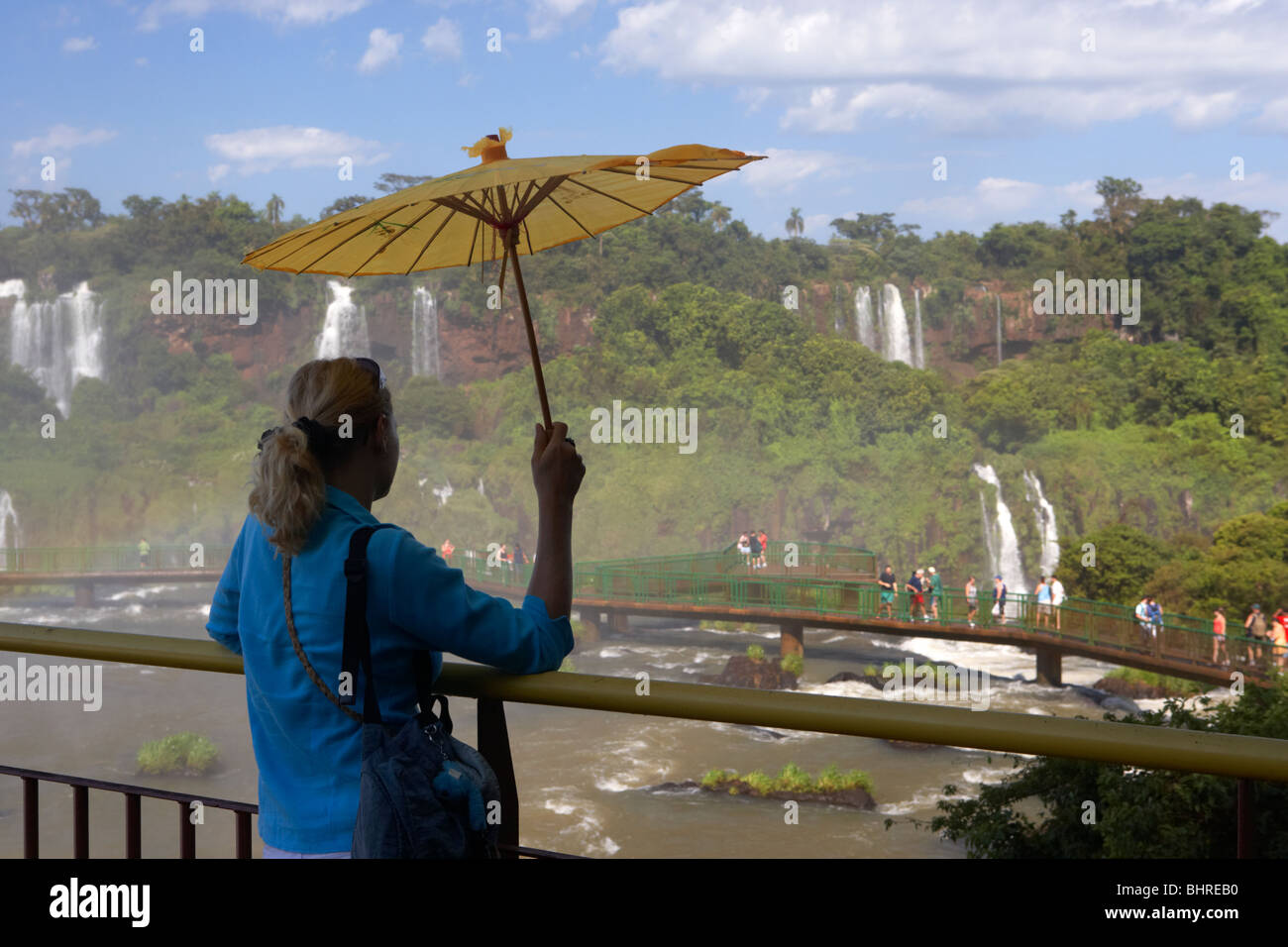 Tour guide holding umbrella attend les touristes sur la plate-forme à la recherche sur les chutes d'Iguaçu côté brésilien la Banque D'Images