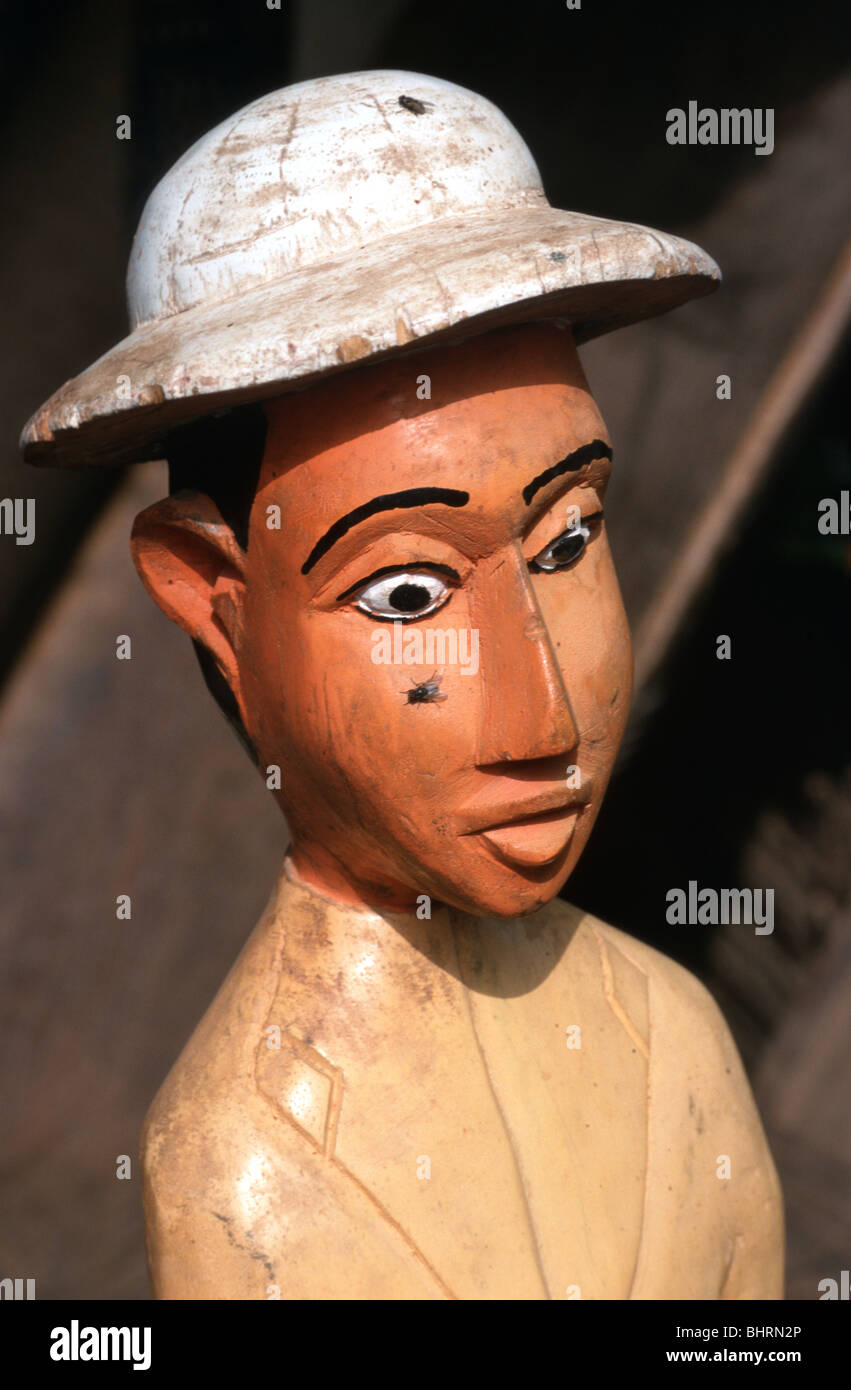 Sculpture en bois d'un homme blanc avec un casque-moelle, avec les mouches, à vendre comme souvenir dans un marché à Ségou, au Mali. Banque D'Images