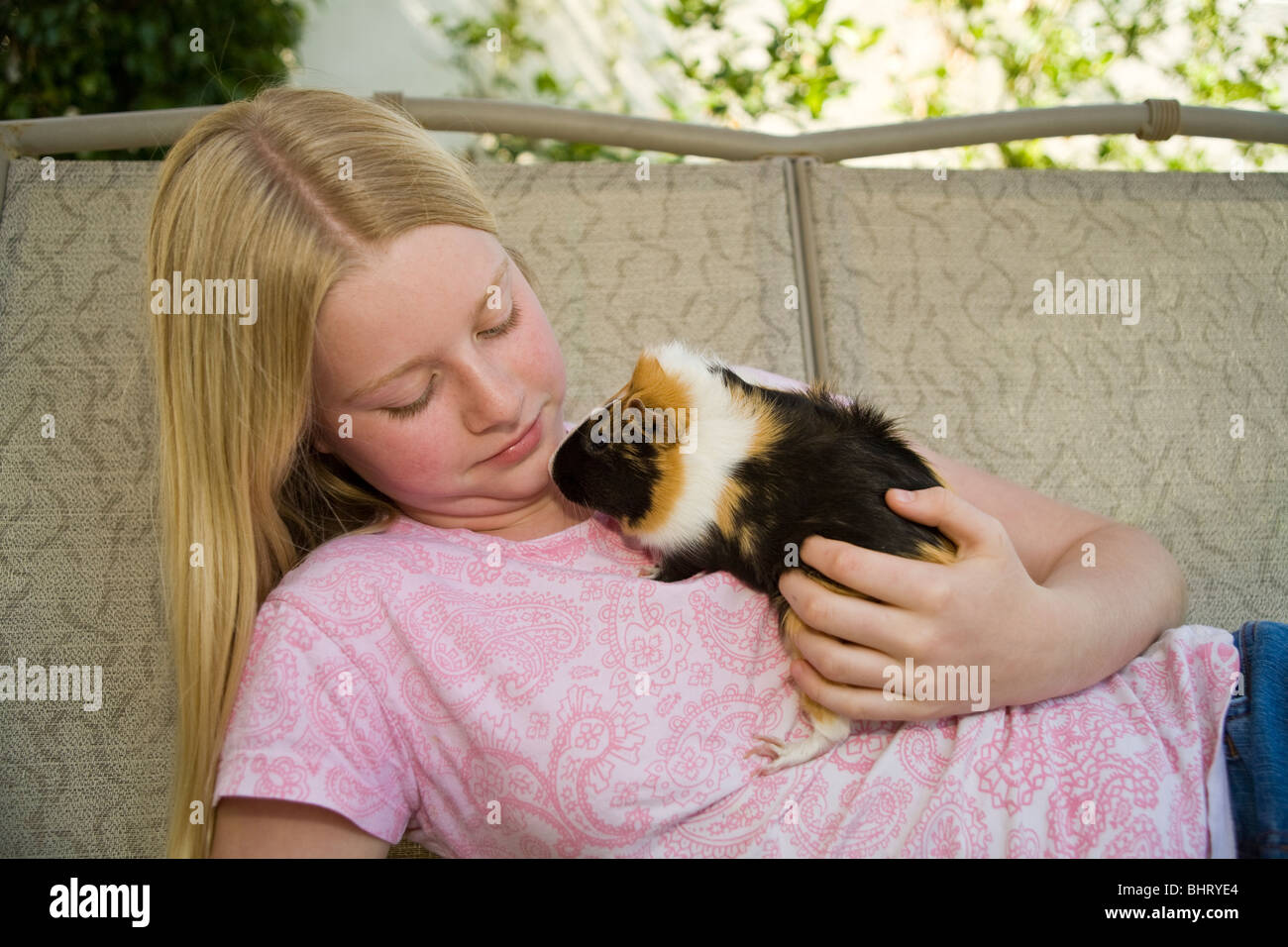 Portrait 10-11 ans, fille, détend, jouant avec sa détente sur cobaye en dehors de swing. United States Monsieur © Myrleen Pearson Banque D'Images