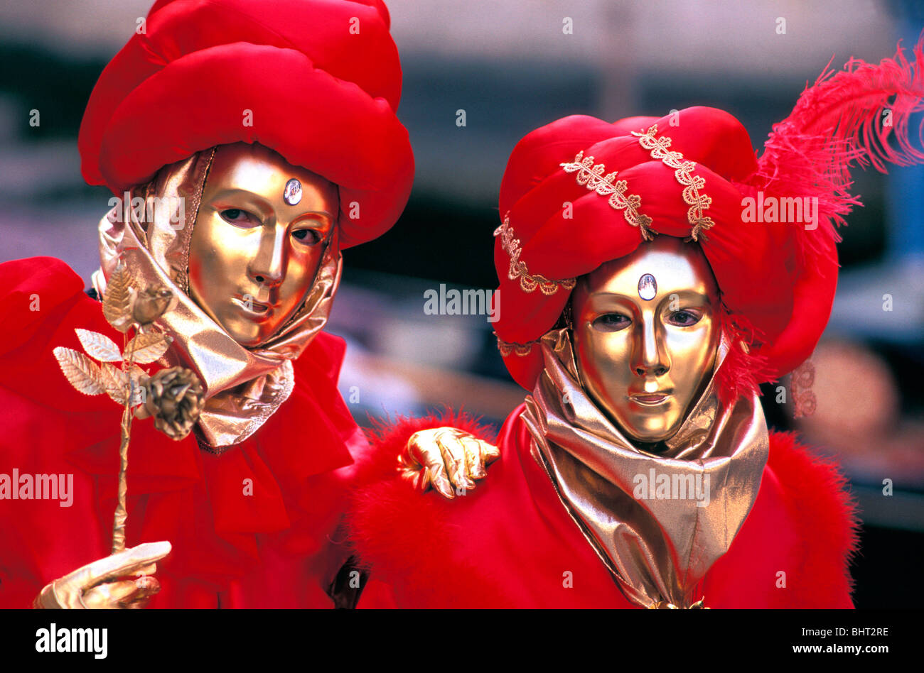 Les masques d'or en couple wearing red turbans & costumes à la Carnaval de Venise 1993 Banque D'Images