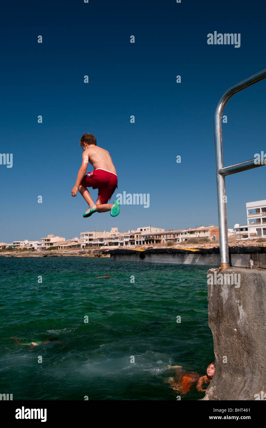 Jeune garçon en rouge pantalon natation sauter haut dans le ciel à partir  d'un tremplin Photo Stock - Alamy