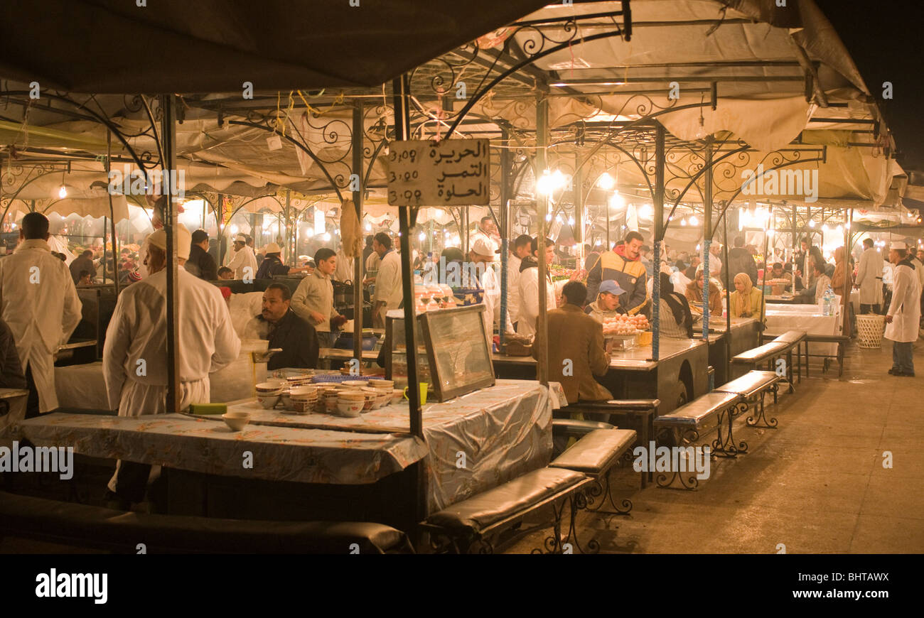 La nuit, la plaza Djem el Fna se transforme en un endroit pour manger, avec de nombreux restaurants à la cuisson des aliments dans une cuisine temporaire Banque D'Images