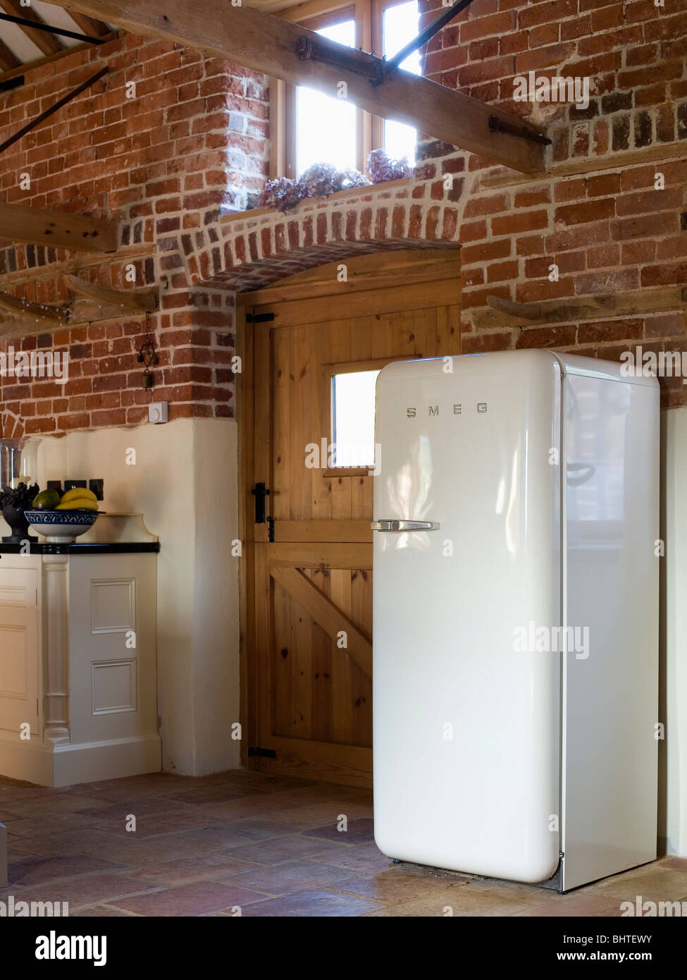 Grand réfrigérateur Smeg blanc grange convertie en cuisine avec murs en  brique Photo Stock - Alamy
