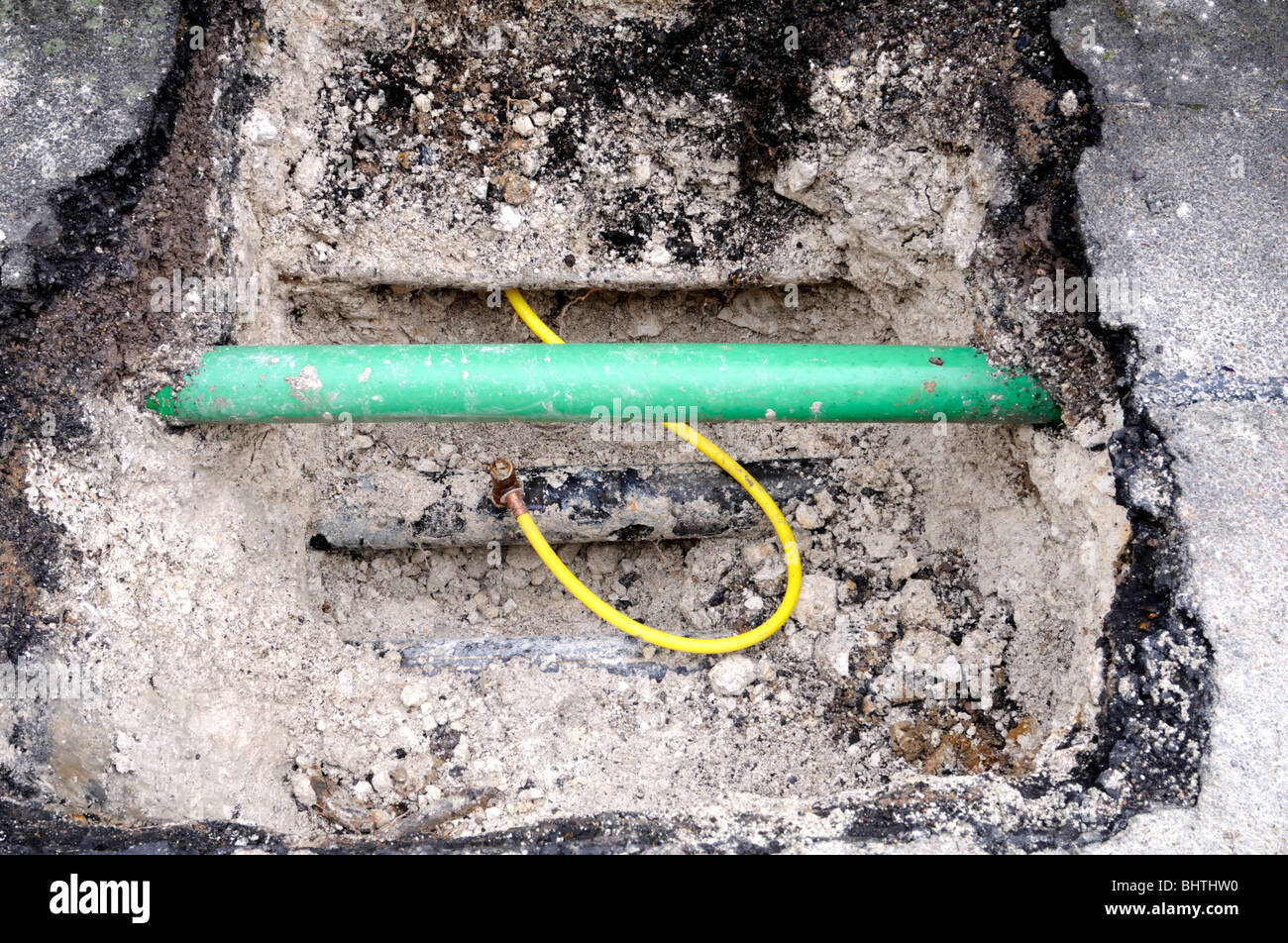 Nouveau tuyau intérieur en plastique jaune est temporairement connecté à l'ancien métal principal tuyau de gaz. Le tuyau vert est pour la fibre optique. Banque D'Images