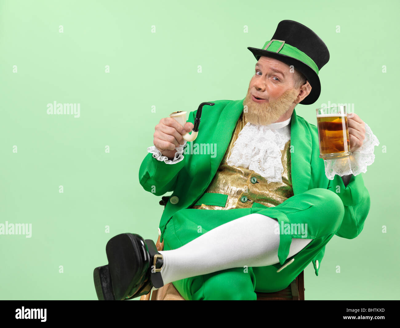 Lutin joyeux dans des vêtements verts tenant une pipe et une bière Banque D'Images