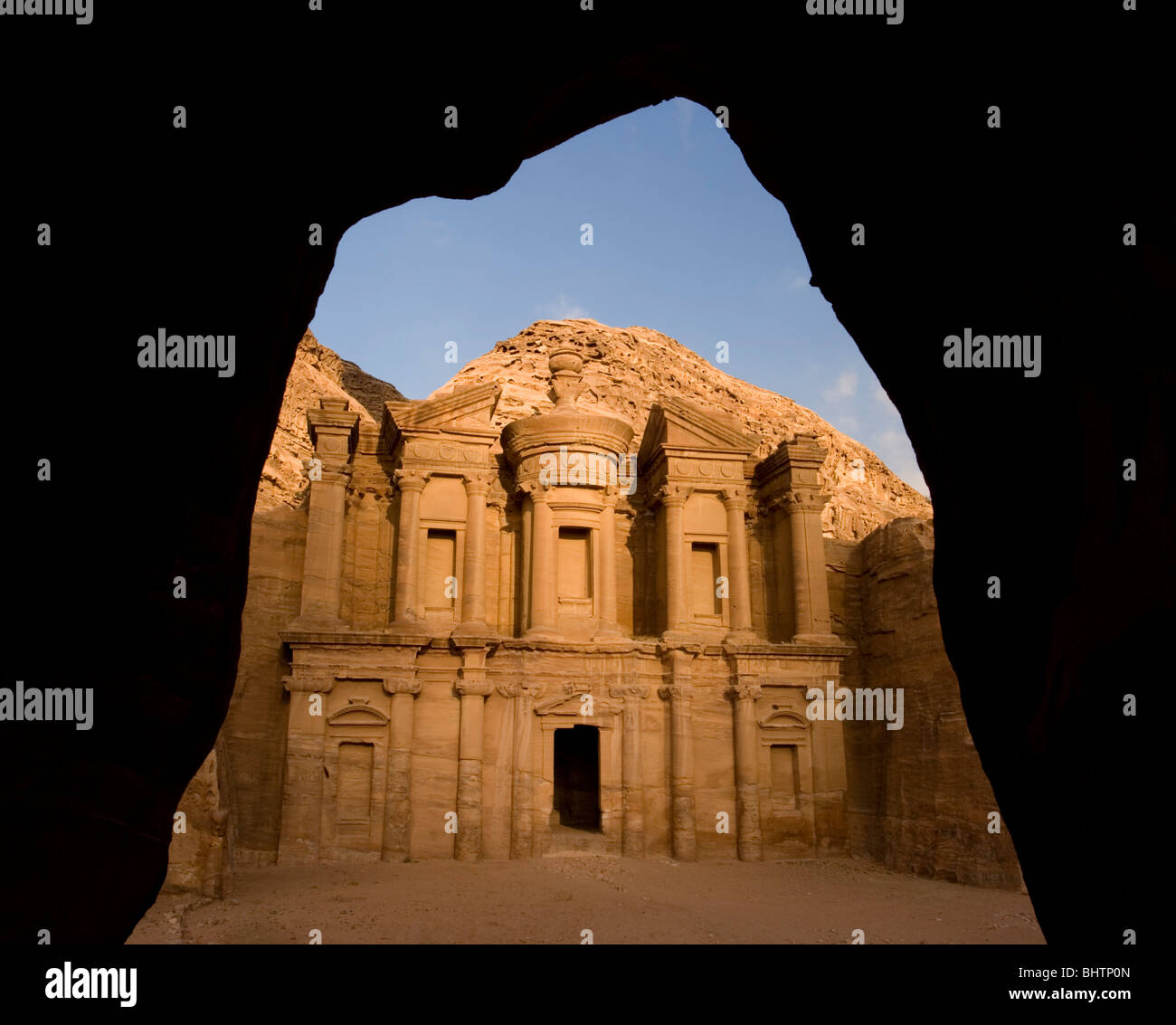 Le monastère de Deir El ou à l'antique cité de Pétra rose rouge vu à travers une arche à Wadi Musa, la Jordanie. Banque D'Images