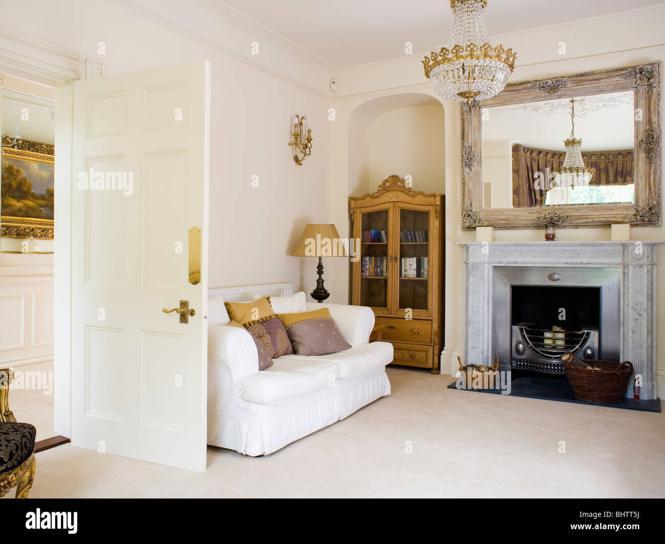 Canapé blanc et crème crème tapis pays salon avec grand miroir au-dessus de cheminée en marbre Banque D'Images