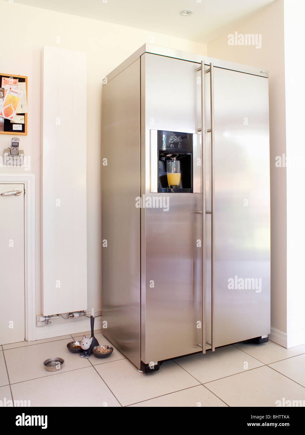 Grand American-style en acier inoxydable réfrigérateur-congélateur à côté  du radiateur blanc vertical dans une cuisine moderne Photo Stock - Alamy