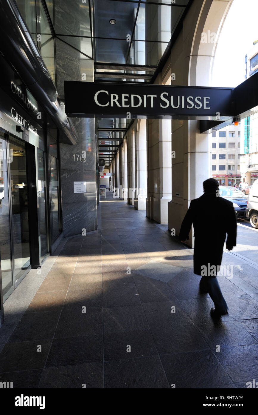 Entrée voûtée de la banque suisse Credit Suisse, ou Crédit Suisse avec un homme marchant dans un trench coat Banque D'Images