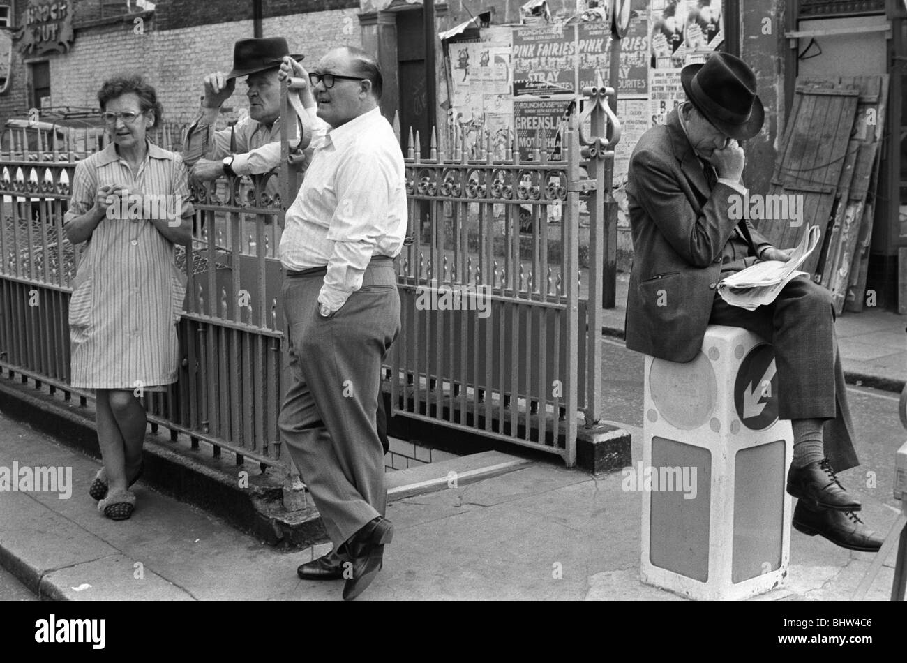 Portobello Road 1970s Royaume-Uni. Groupe d'amis des gens qui parlent ensemble dans la rue. Notting Hill West London Angleterre 1975 .les rampes métalliques entourent les marches qui descendent dans les toilettes publiques à la jonction de Portobello Road et Talbot Road. HOMER SYKES Banque D'Images