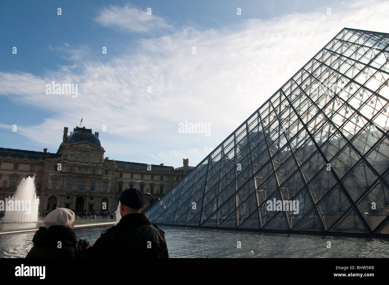 Couple de personnes âgées à la pyramide du Louvre à Paris Banque D'Images