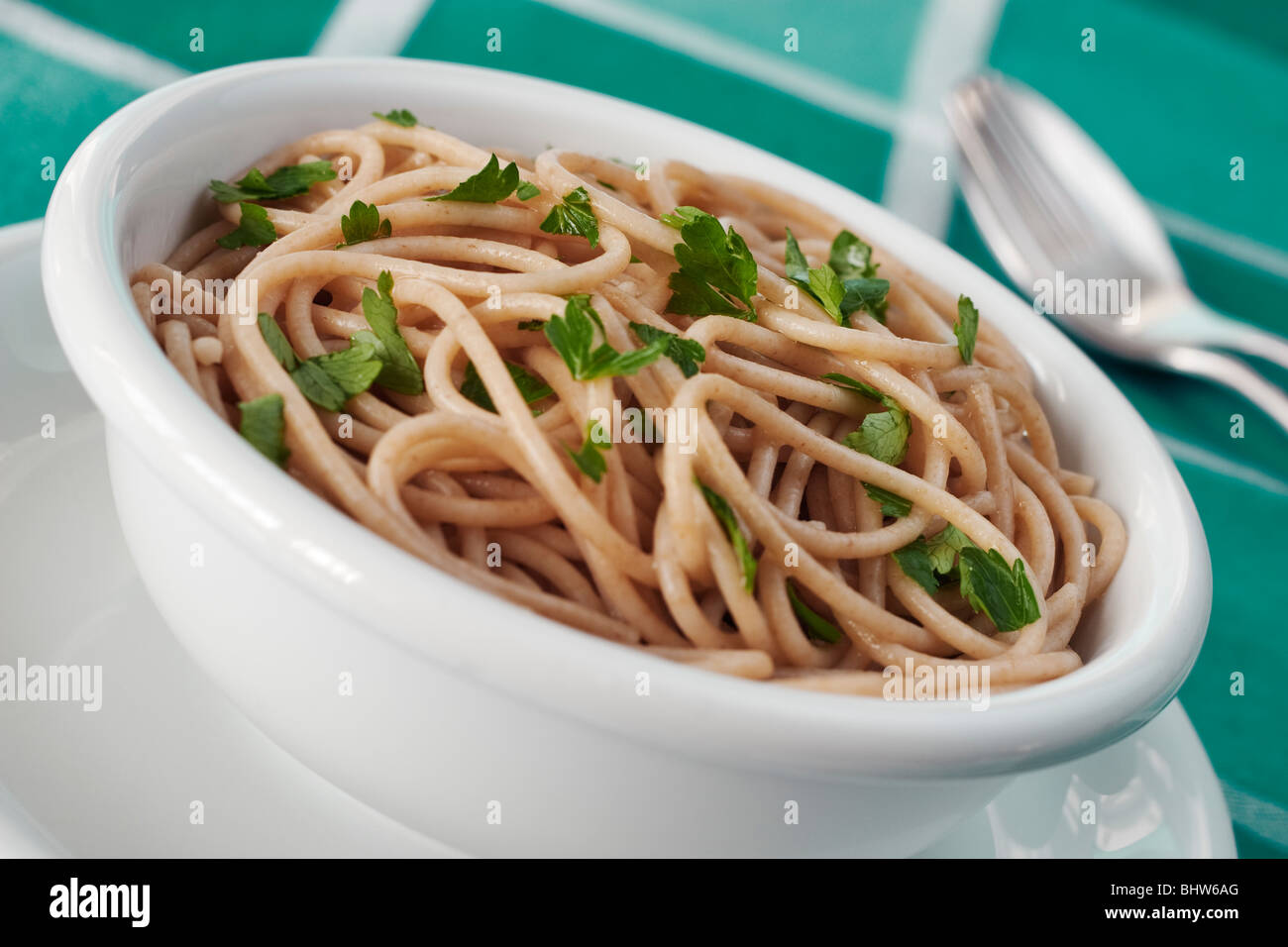 Un bol de spaghetti complet garni de persil Banque D'Images