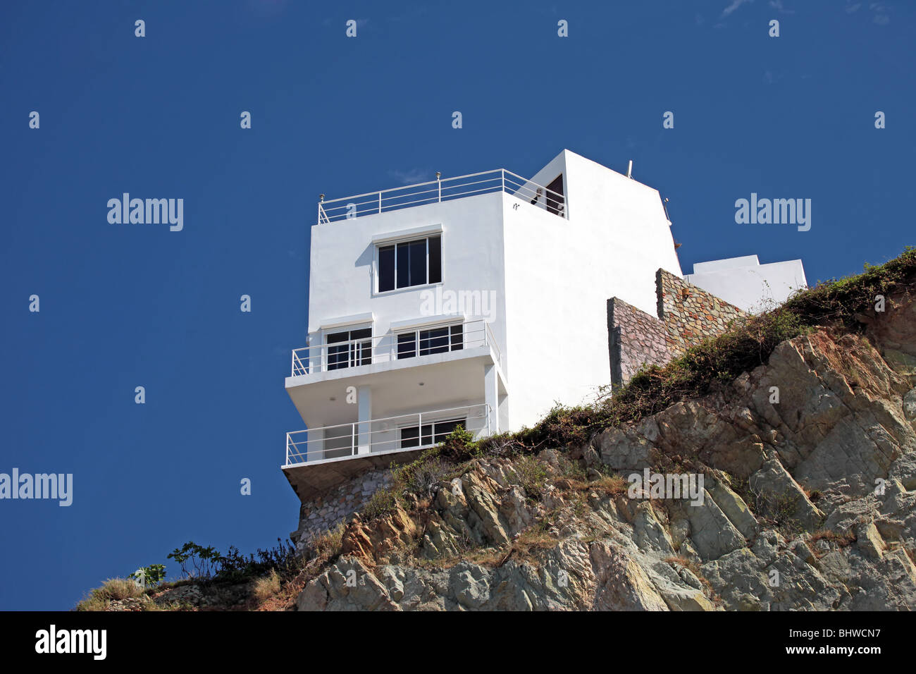 Accueil de luxe peint en blanc sur le sommet d'une montagne rocheuse au Mexique. Pour voir d'un balcon chambre surround de l'océan Pacifique. Banque D'Images
