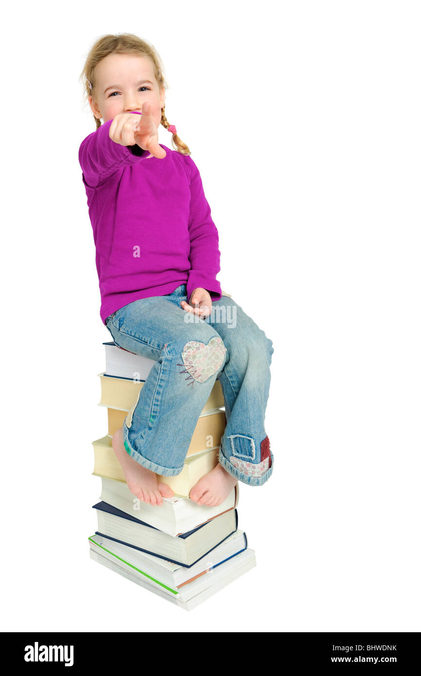 Studio photo de plein isolé un jeune enfant assis sur des livres Banque D'Images