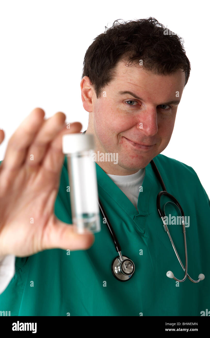 Man wearing scrubs medical tirant funny face sarcastique holding out modèle bouteille d'échantillon Banque D'Images
