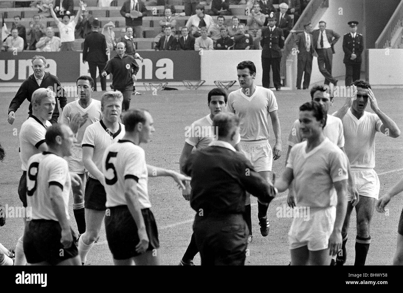 Coupe du Monde de Football 1966 en Allemagne de l'Ouest v Uruguay arbitre Jim Finney arrêtés Uruguays Horacio Troch hors du terrain après qu'il ait l'Allemagne fowled Emmrich dans la seconde moitié. ©1960 Mirrorpix Banque D'Images