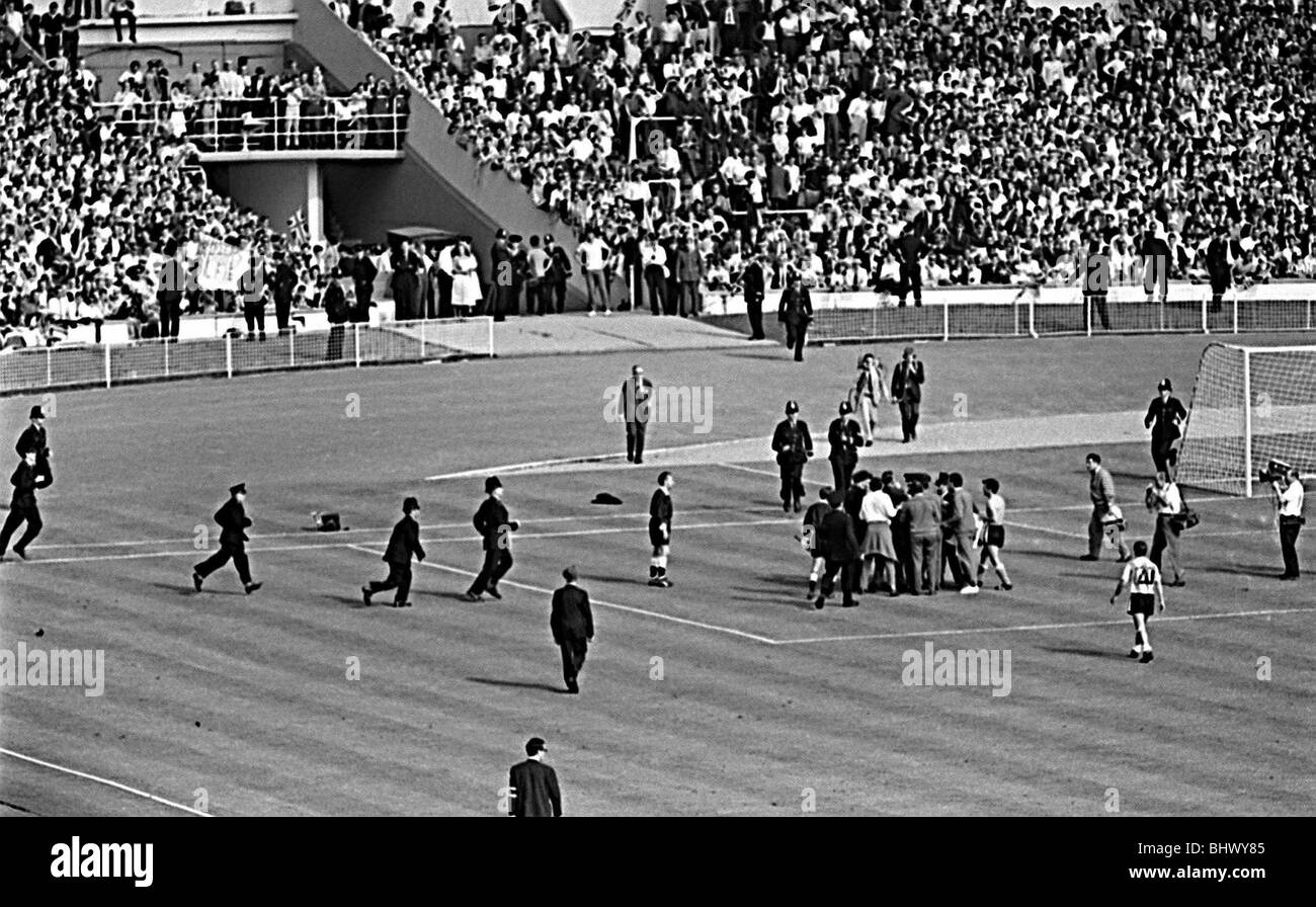 Sur le terrain de la police que l'Angleterre v la Coupe du Monde 1966 Argentine jeu après coup de sifflet final où l'arbitre Rudolph Kreitlin a été confronté à des joueurs argentins en colère en raison d'être Rattin envoyé Banque D'Images