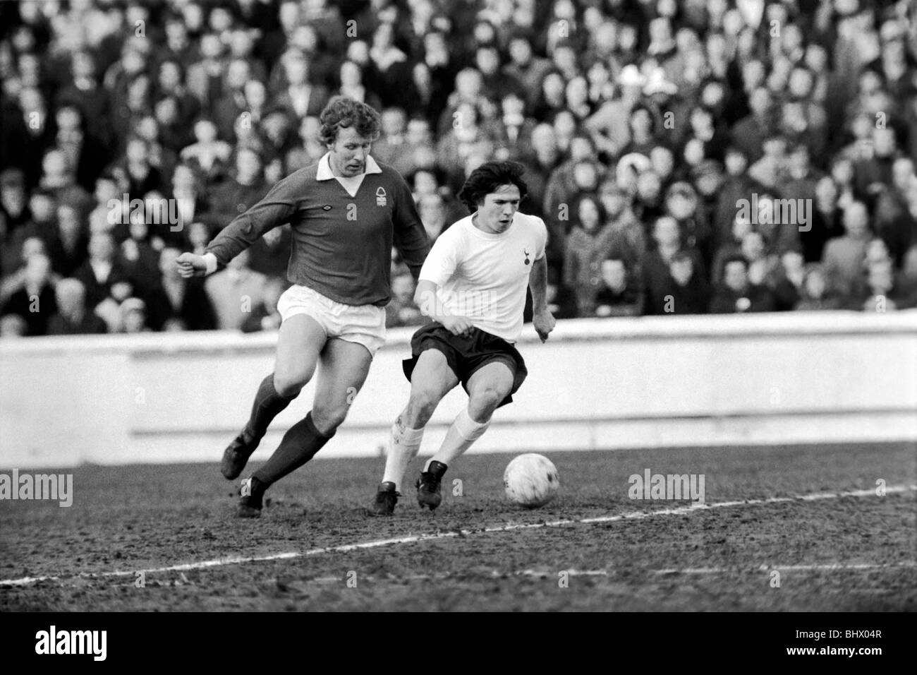 Football : F.A. Cup : Notts Forest (1) vs Tottenham Hotspur (1). Steve Perryman (droite) dwarfted par Chapman. Janvier 1975 Banque D'Images