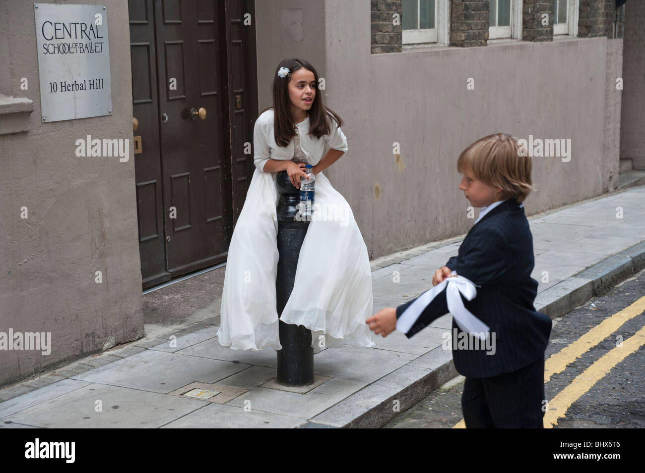 Jeune fille en premier auteur de la robe blanche sur le bollard vu par boy en noir devant notre Dame du Mont Carmel procession Banque D'Images