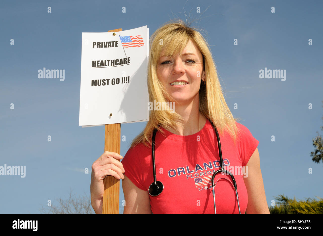 Private Healthcare en France doit aller porter manifestant femelle chemise rouge et la tenue d'un stéthoscope Banque D'Images