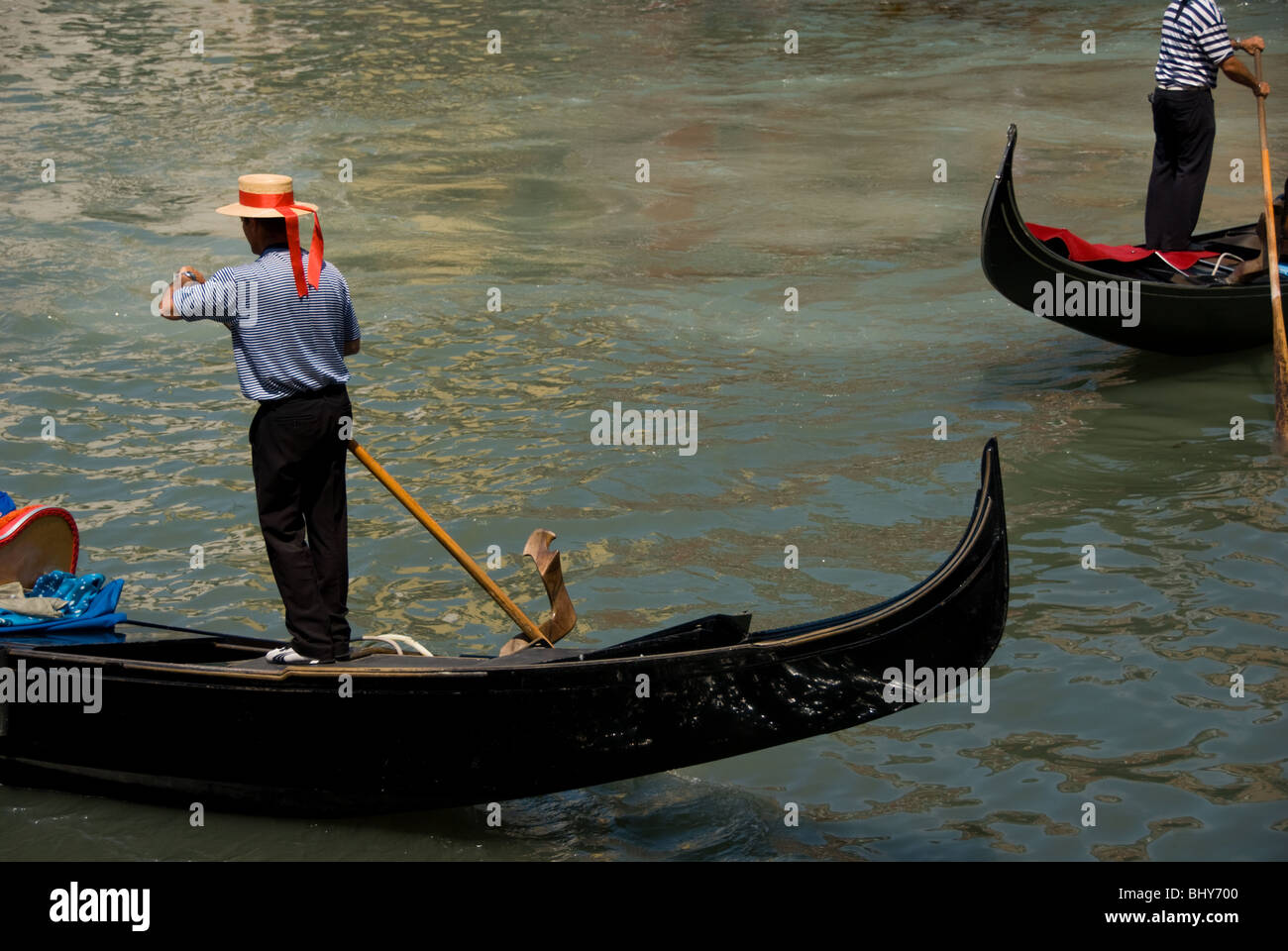 Gondoliers au travail le long du Grand Canal de Venise. Banque D'Images