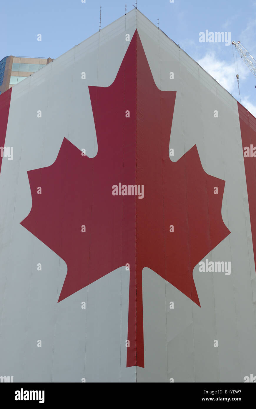 Très grand drapeau canadien enroulé autour d'un bâtiment. Banque D'Images