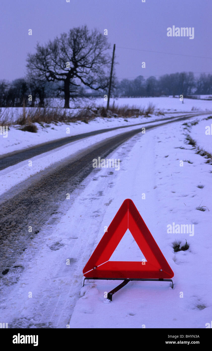 Triangle de présignalisation sur le champ en wintersnow d'avertissement danger possible sur route de campagne hiver près de Leeds Yorkshire UK Banque D'Images