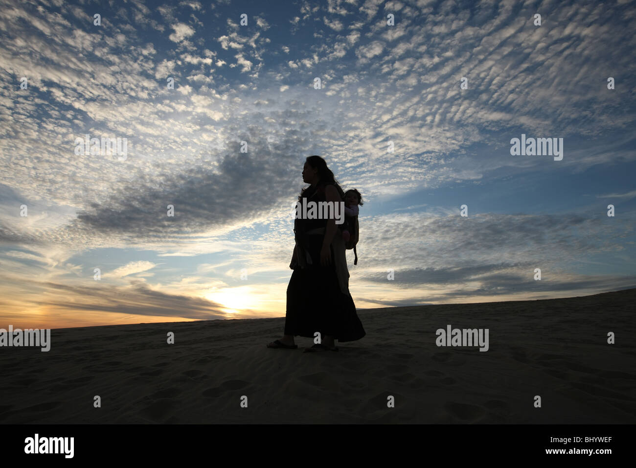 Femme et son bébé randonnée pédestre les dunes de sable de l'Outer Banks , NC. Banque D'Images