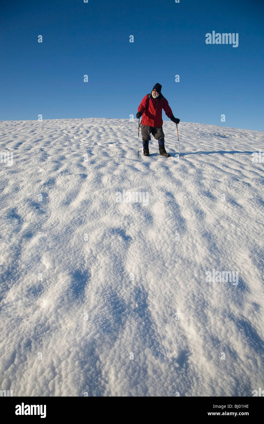 Randonneur plus Comergah d'escalade dans la neige des montagnes, comté de Waterford, Irlande Banque D'Images