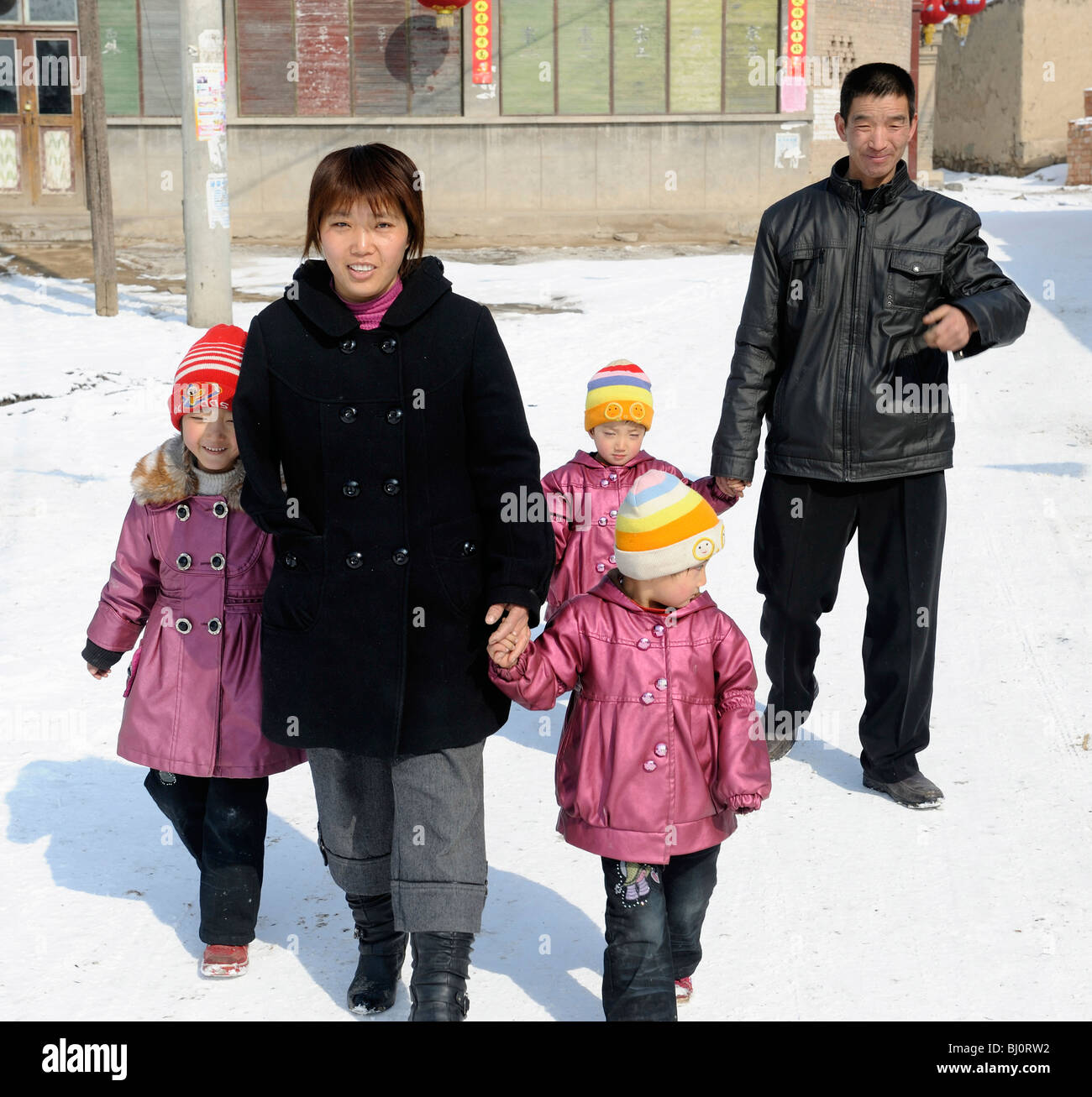Couple chinois avec trois filles marcher dans une rue de village Nuanquan, province de Hebei, Chine. 01-Mar-2010 Banque D'Images