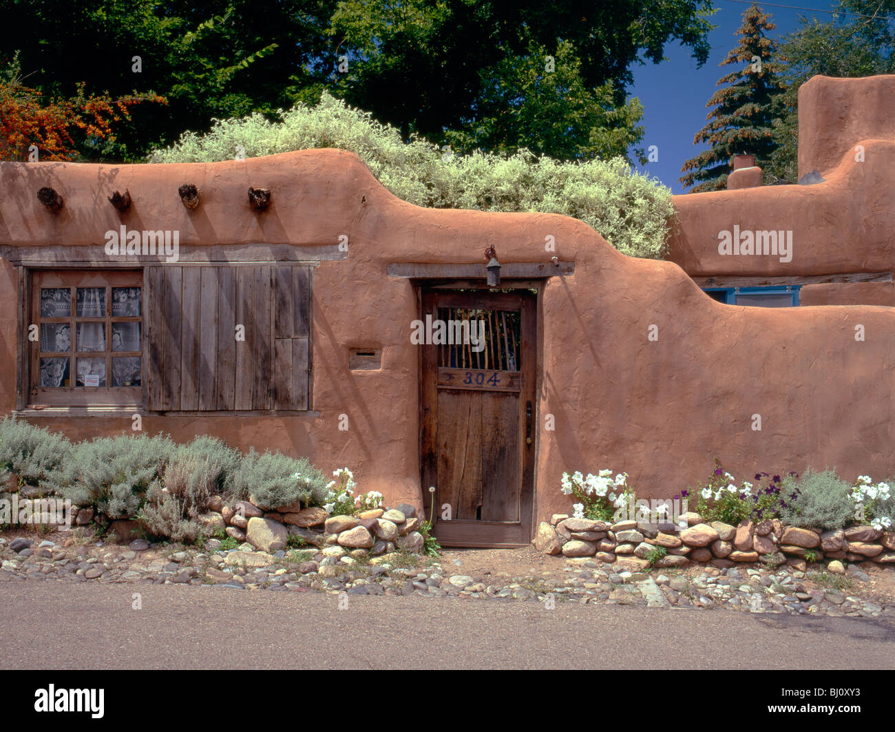 Adobe mur, porte et jardins de la maison le long de Canyon Road, site de galeries & magasins, Santa Fe, Nouveau Mexique, États-Unis Banque D'Images