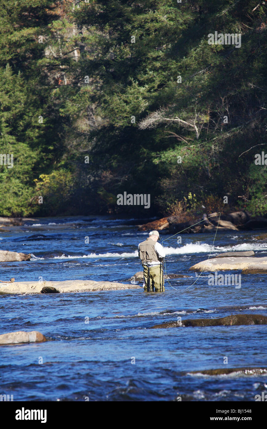 FLY FISHERMAN WADING IN RIVER COURSE RAPIDE À LA RECHERCHE DE FONTAINE RIVIÈRE TOCCOA EN GÉORGIE Banque D'Images