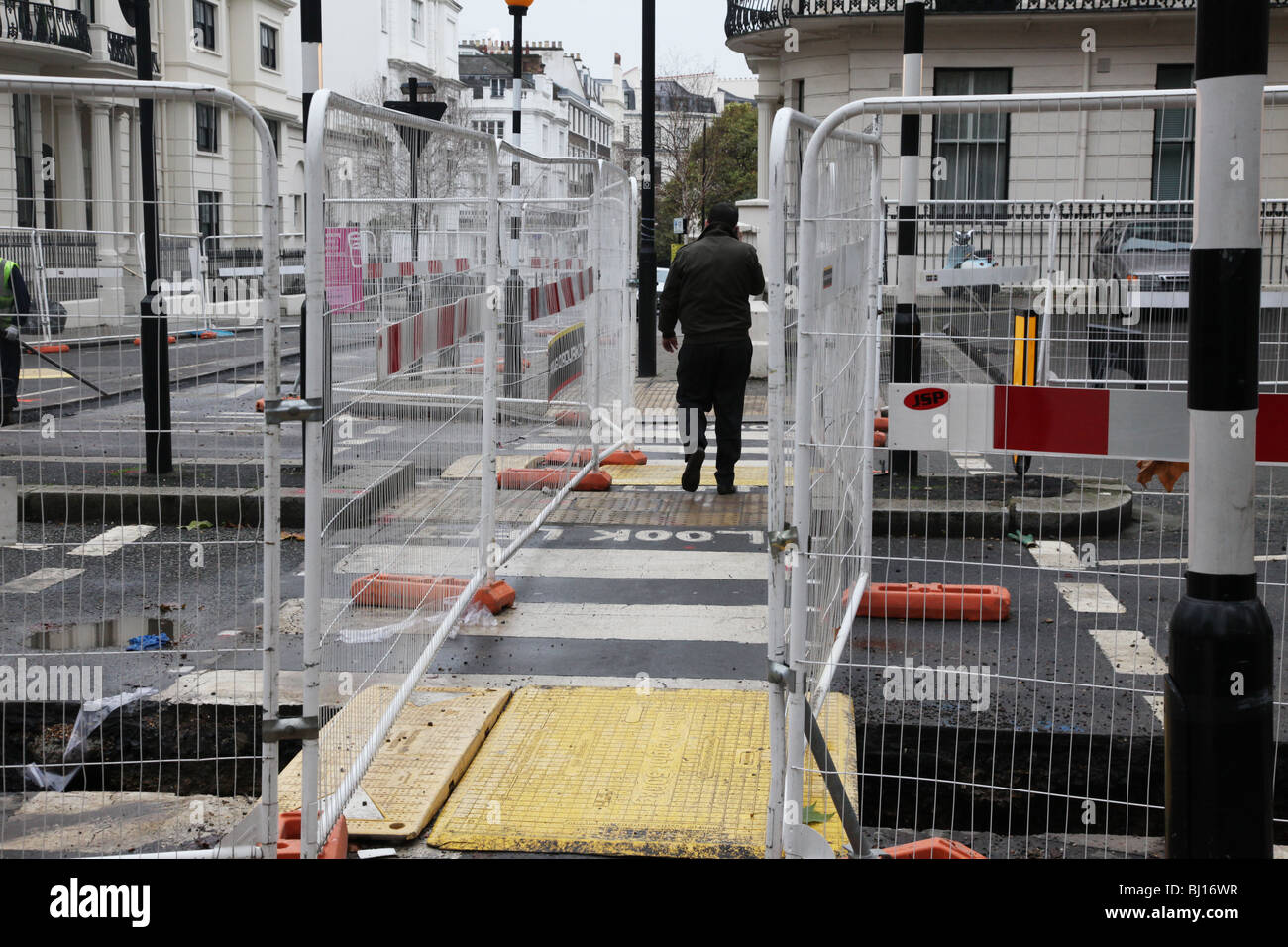 L'homme de traverser la route avec les travaux de construction Banque D'Images