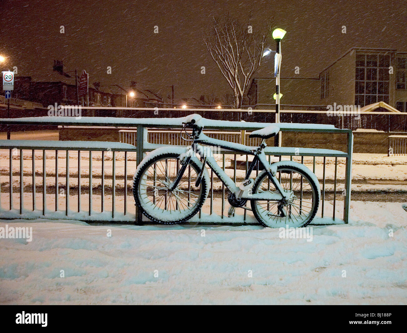 Vtt attaché à une main courante des rue de Londres après de fortes chutes de neige Banque D'Images