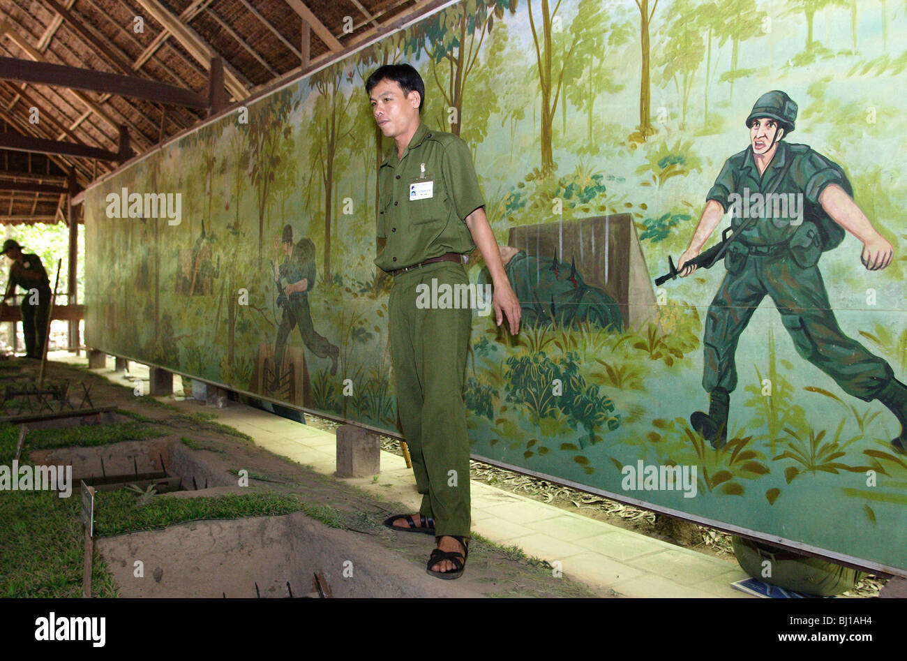 Employé du Musée montre les pièges dans le Musée des débris de guerre, Cu Chi, Vietnam Banque D'Images