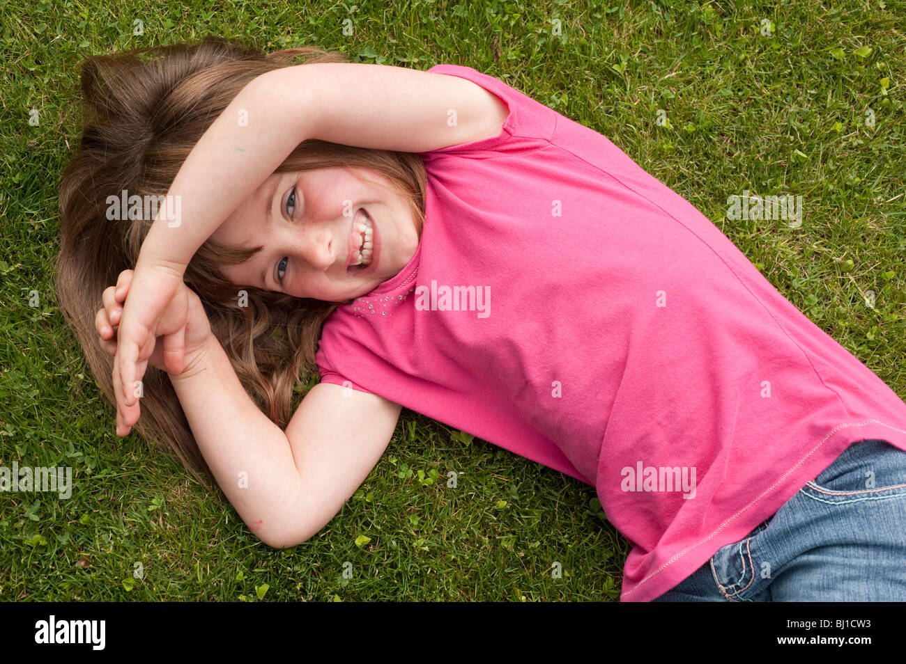 Petite fille (5 ans) portant sur l'herbe Banque D'Images