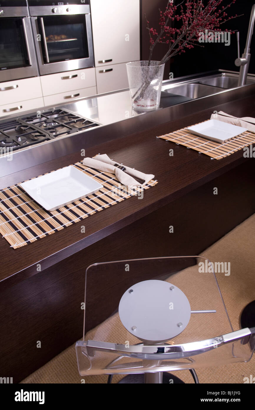 Cuisine moderne de couleur marron et blanc avec four double et petit déjeuner en face de la cuisinière Banque D'Images