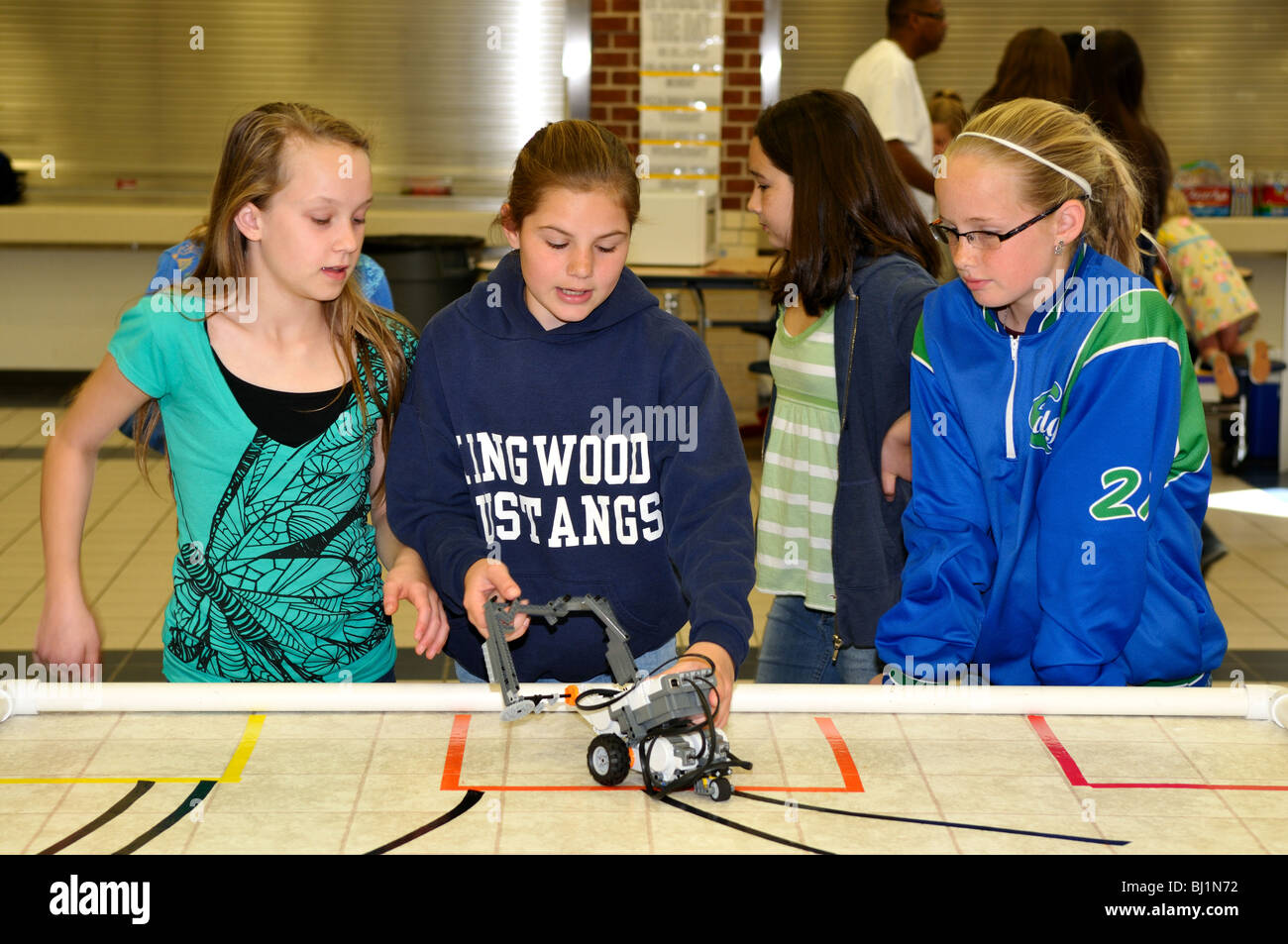 Filles de l'école de l'essai d'un robot Lego voiture pendant une expo-sciences. Banque D'Images
