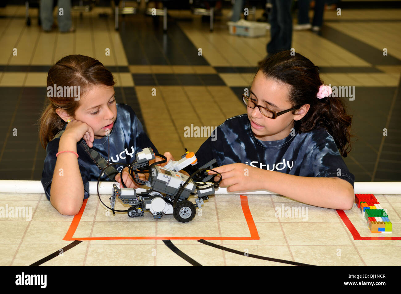 Deux filles de l'école de travailler sur un robot voiture. Banque D'Images