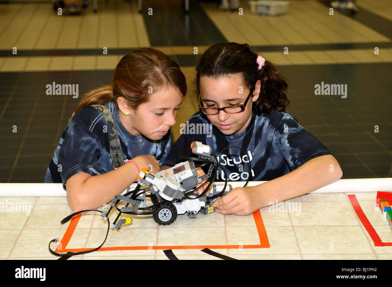 Deux filles de l'école de travailler sur un robot voiture. USA. Banque D'Images