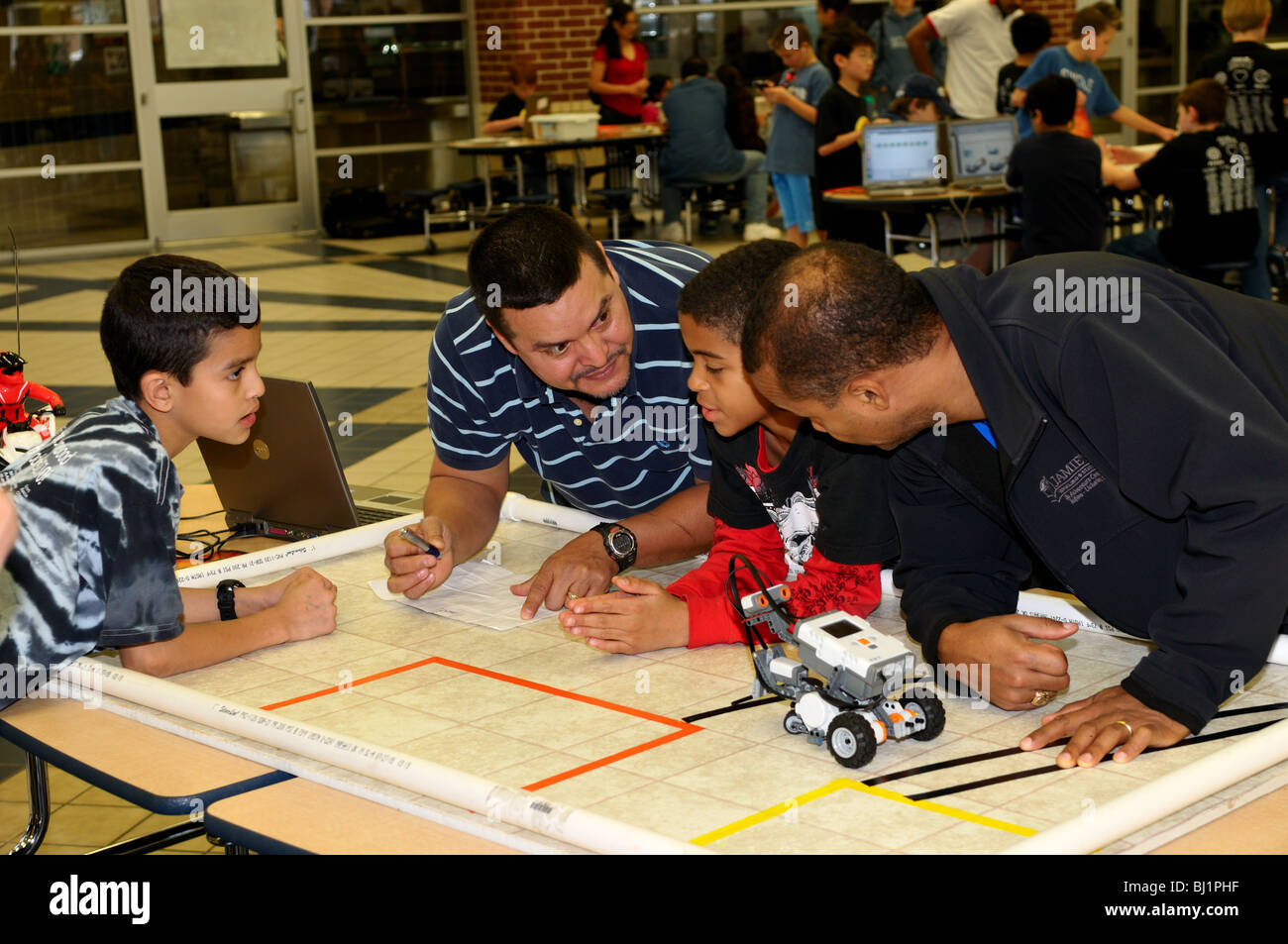 Les parents à aider les enfants de concevoir et de tester un robot voiture pendant une expo-sciences. Banque D'Images
