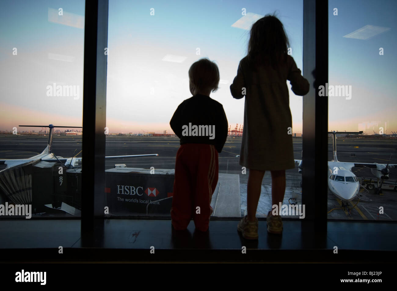 Regarder un enfant à travers une fenêtre d'aviation Banque D'Images