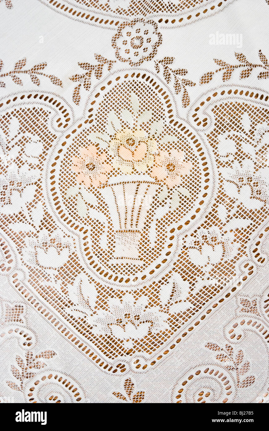 Photo d'une nappe en dentelle avec motif floral et de vase. Banque D'Images