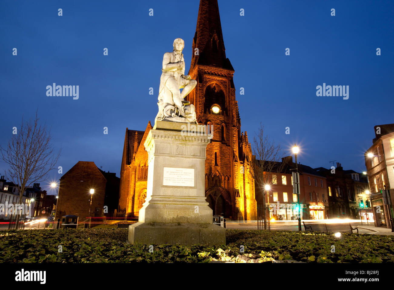 Le poète Robert Burns statue en Dumfries centre-ville avec l'église de Greyfriars derrière la nuit Ecosse UK Banque D'Images